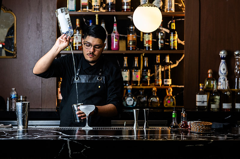 bartender pouring drink at high praise